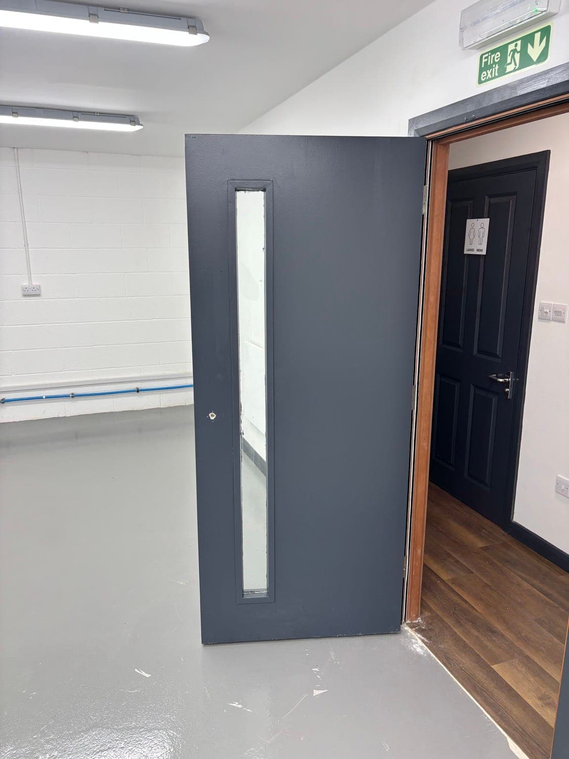 Grey composite external door and black internal door newly fitted, with wood-effect flooring
