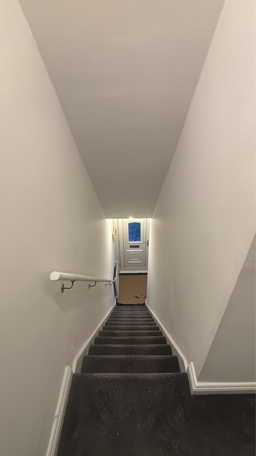 Hallway and stairs painted white with a new handrail and grey carpet
