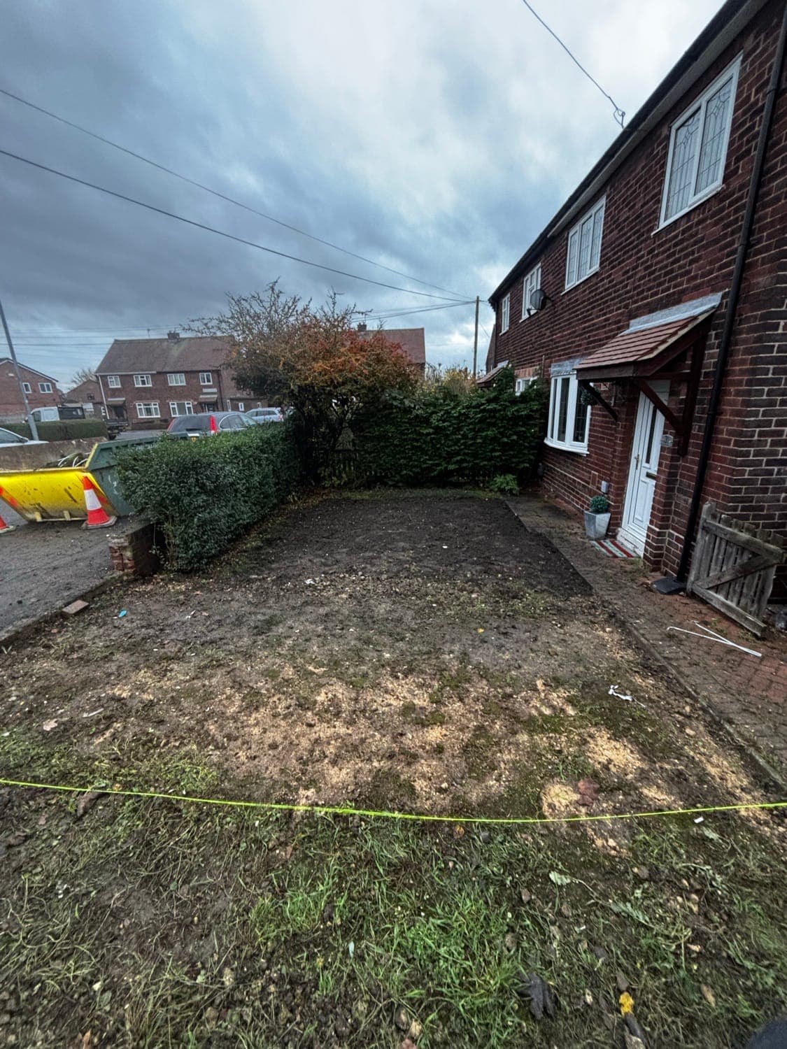 The same front garden before the driveway, cleared to bare soil and marked out with string