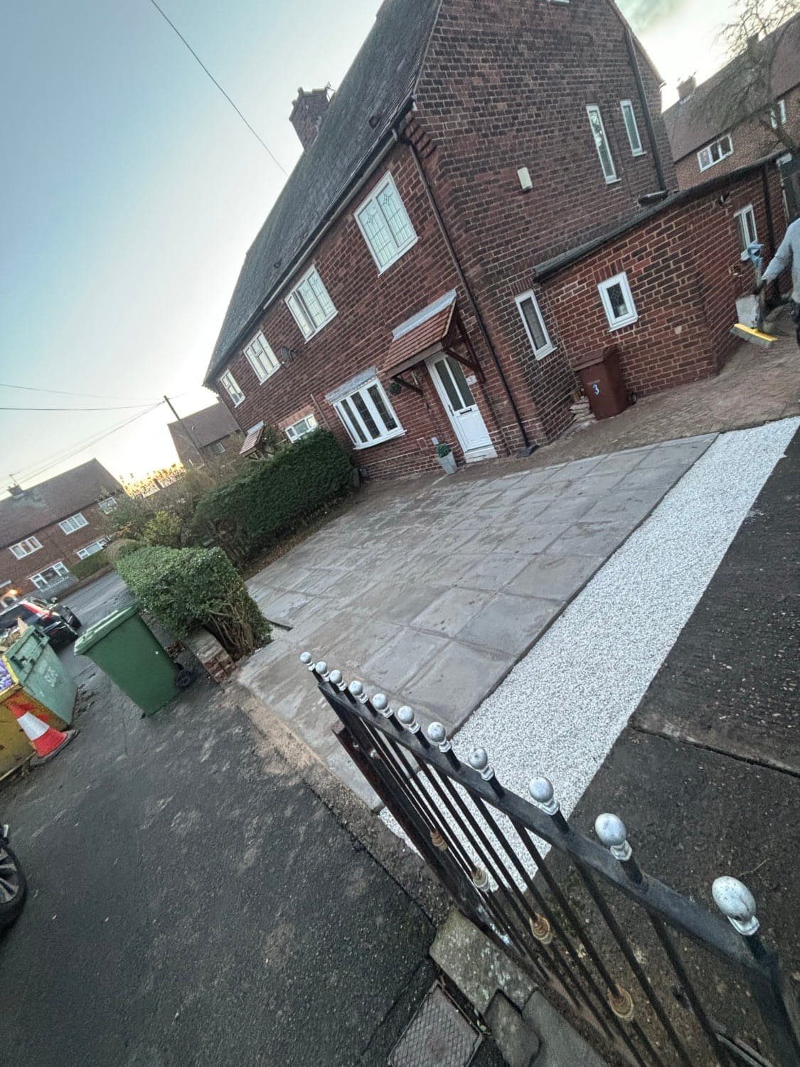 Front driveway paved with concrete slabs and finished with a white gravel border