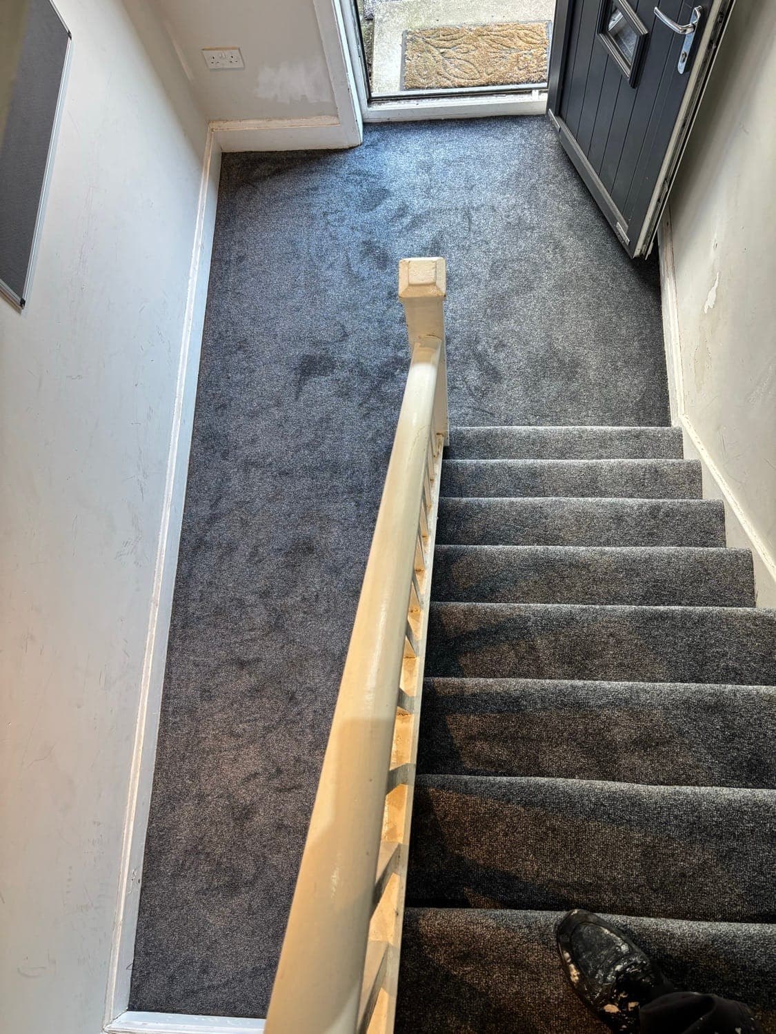 Staircase fitted with grey carpet, with the banister and spindles painted white